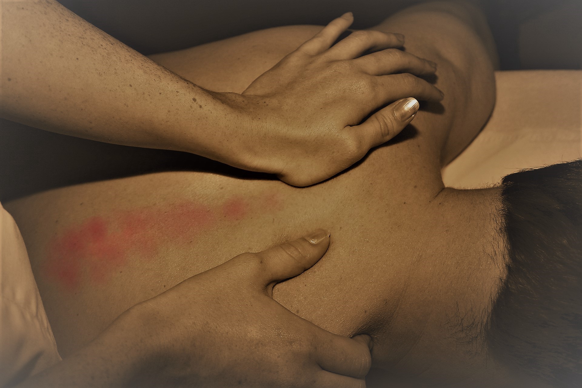 Hands massaging a sore back.